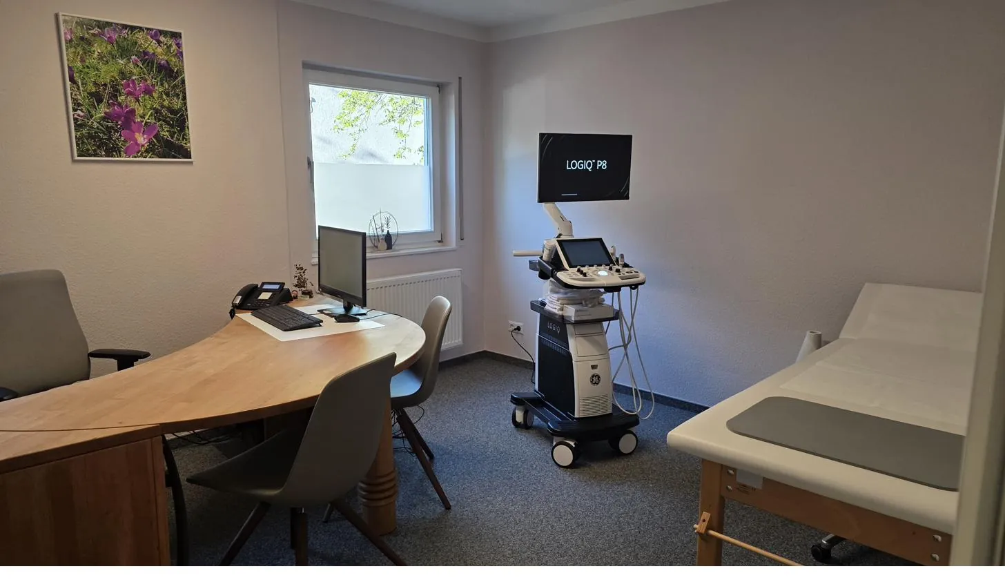 Behandlungszimmer mit Schreibtisch, Untersuchungsliege und Ultraschallgerät